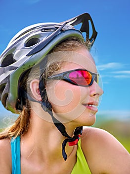 Bikes cycling girl wearing helmet rides bicycle aganist blue sky.