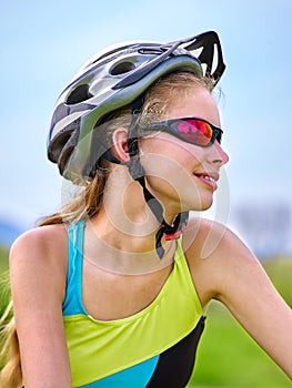 Bikes cycling girl wearing helmet rides bicycle aganist blue sky. photo