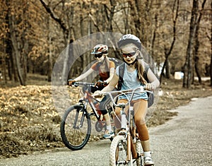 Bikes girls with rucksack cycling on bicycle. Toned sepia image.