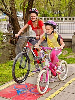 Bikes girls with rucksack cycling on bike lane.