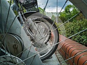 Bikes standing on bike station on sidewalk