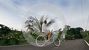 Biking road trip. The man on blue bike in white clothes on forest road. The biker men ride on bicycle. Cycling Cycle Fix