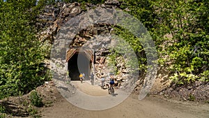 Biking into a tunnel of the abandoned Kettle Valley Railway carved in the rocks of Myra Canyon