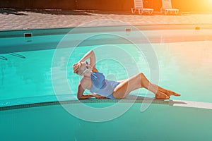 Bikini-clad woman enjoys poolside relaxation. Poolside ambiance. Capturing woman& x27;s relaxed time near pool.