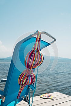 Bikini drying on a deck chair on a pier