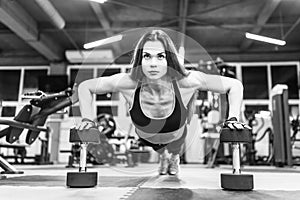 Bikini fitness girl working out with dumbbells. Athlete woman in sportswear doing exercise in gym.