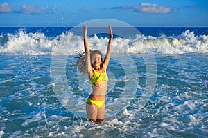 Bikini girl jumping in Caribbean sunset beach