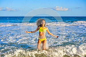 Bikini girl jumping in Caribbean sunset beach