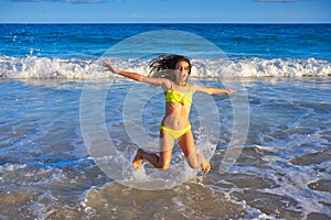 Bikini girl jumping in Caribbean sunset beach