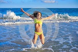 Bikini girl jumping in Caribbean sunset beach