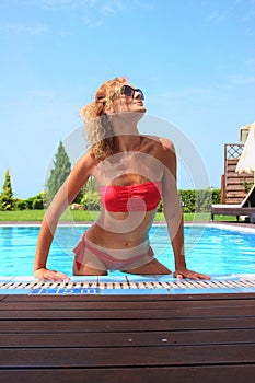 Bikini model in pool with clear blue water