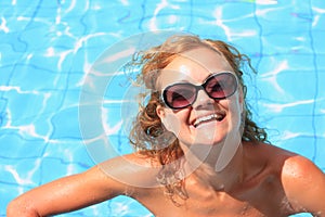Bikini model in pool with clear blue water