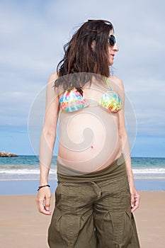 Bikini pregnant at beach looking aside
