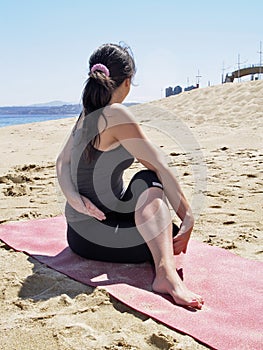 Bikram yoga arda matsyendrasana pose at beach