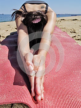 Bikram yoga ardha kurmasana pose at beach