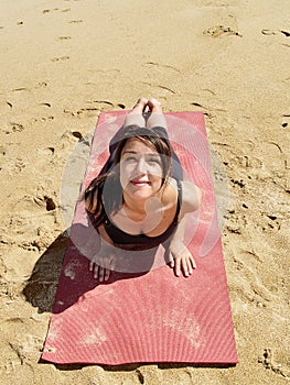 Bikram yoga bhujangasana pose at beach photo