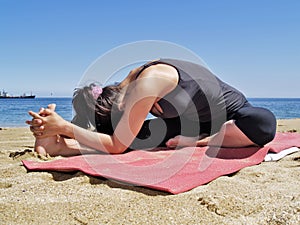 Bikram yoga janushirasana pose at beach