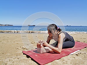 Bikram yoga paschimottanasana pose at beach