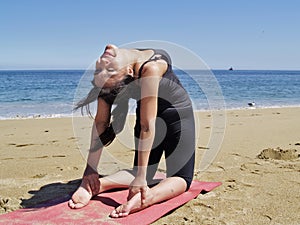 Bikram yoga ustrasana pose at beach photo