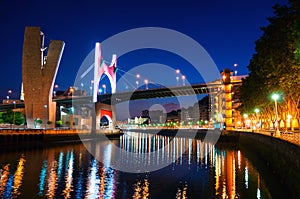 Illuminated Salbeko zubia Bridge over Nevion River in Bilbao, Spain at night photo