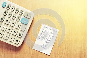 Bill and calculator with wooden