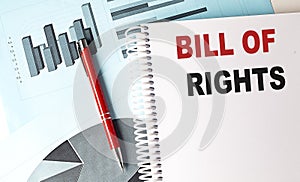 BILL OF RIGHTS text on a notebook with pen on a chart background
