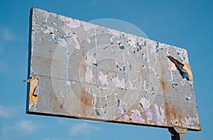 Billboard with rusted structure against blue sky for advertisement