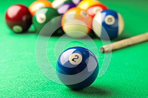 Billiard ball with number 2 on green table, closeup