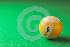 Billiard ball with number 9 on green table, space for text