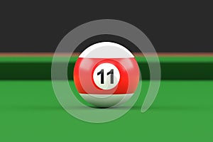 Billiard ball number eleven in red and white color on billiard table