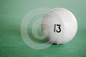 Billiard Ball number 13 on a pool table. A close-up image of an number thirteen ball on a pool table