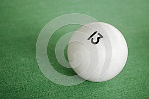 Billiard Ball number 13 on a pool table. A close-up image of an number thirteen ball on a pool table