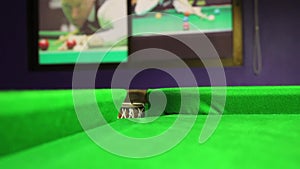 Billiard ball rolling into a hole on a pool table