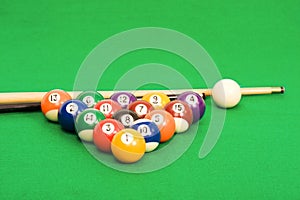 Billiard balls arranged on a green pool table