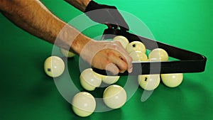 Billiard balls arranged in a triangle. Green table.