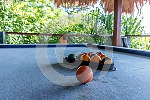 Billiard balls in a blue pool table, game. Outside, tropical cafe, Bali island.