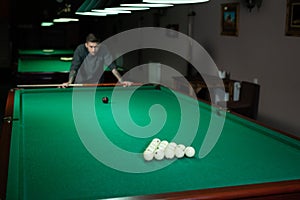 Billiard balls in a green billiard table. A man playing Billiards.