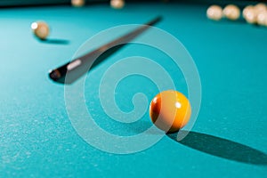 Billiard balls on green table with billiard cue.