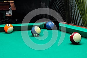 Billiard balls on green table and blue ball in pocket