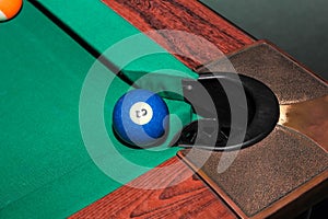 Billiard balls on green table and blue ball in pocket