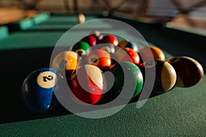 Billiard balls on green table in sunset light