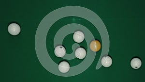 Billiard balls are laid out in the shape of a triangle on a green table.