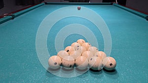 Billiard balls are laid out in the shape of a triangle on a green table of Russian billiards. Ivory balls