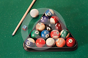 Billiard balls near by cue and chalk.