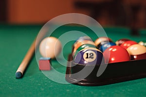 Billiard balls near by cue and chalk.