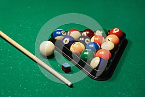 Billiard balls near by cue and chalk.