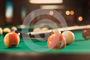 Billiard balls near by cue on the pool table.