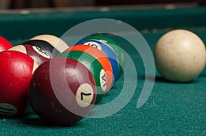 Billiard balls and a stick on a green table. Billiard balls isolated on a green background