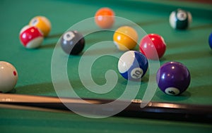 Billiard balls on a table with a cue