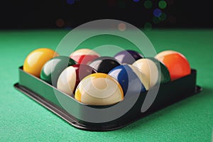 Billiard balls in triangle rack on green table, closeup